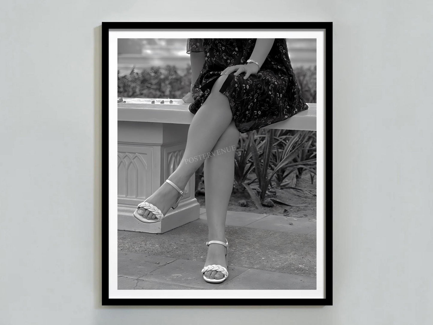Framed black and white photograph of a person sitting outdoors wearing high heels.