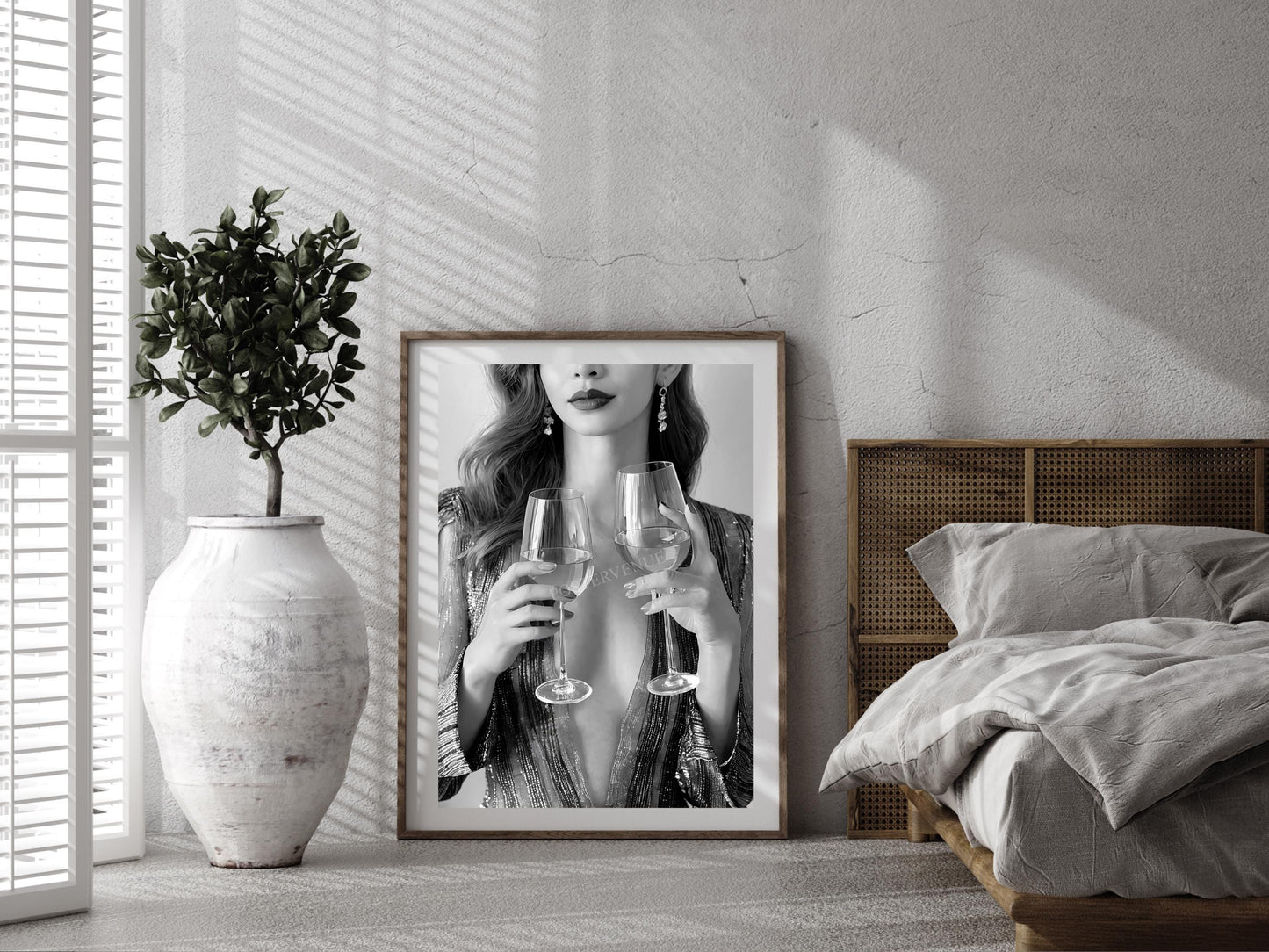Framed artwork of a woman holding wine glasses in a bedroom setting.