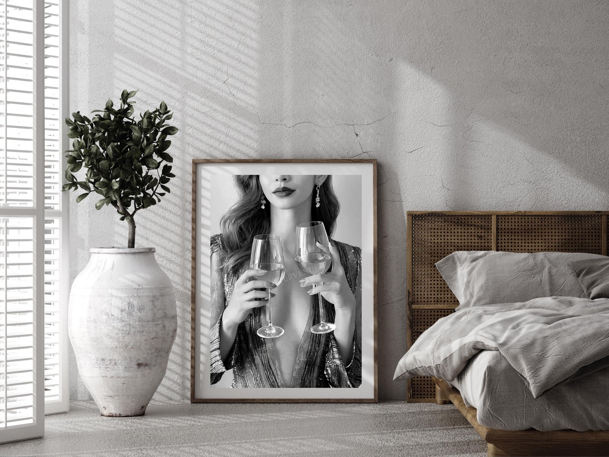 Framed artwork of a woman holding wine glasses in a bedroom setting.