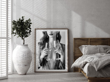 Framed artwork of a woman holding wine glasses in a bedroom setting.