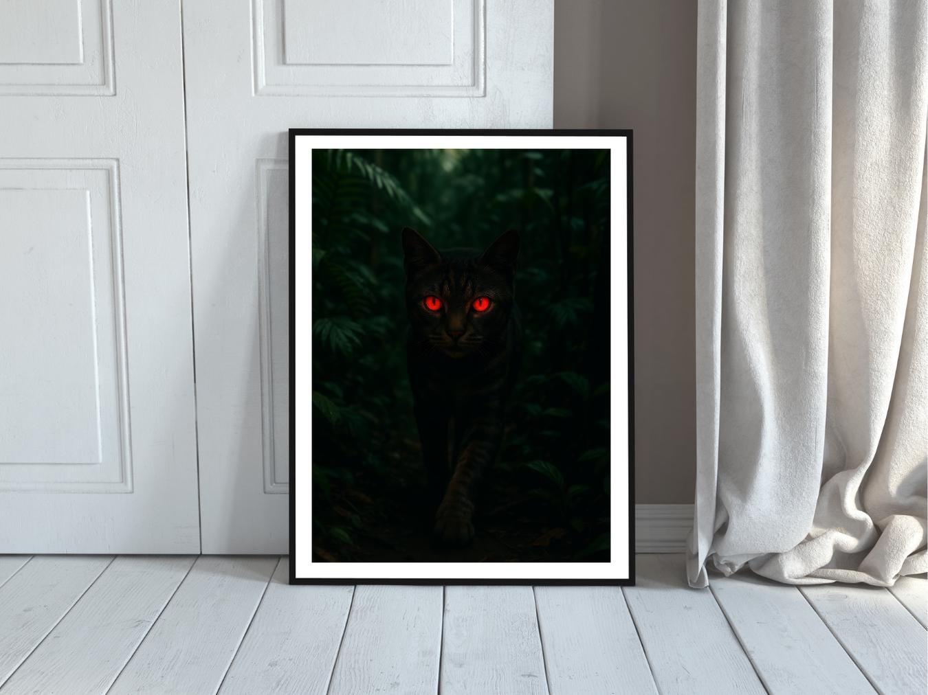 Framed artwork of a black cat with glowing red eyes on a white wall.